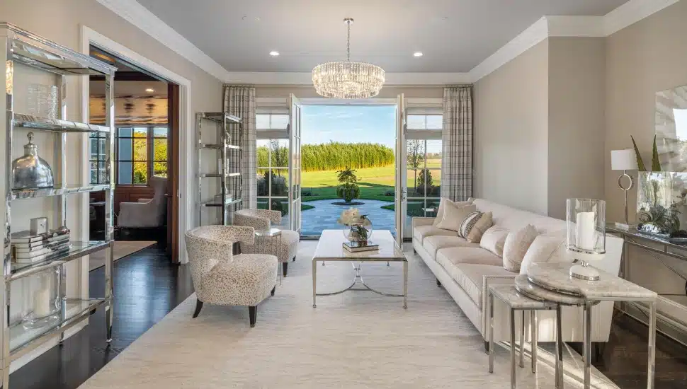 sitting room mostly white furniture with bucolic view in background