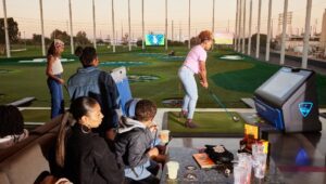 two women teeing off at a Topgolf venue