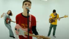 jsolomon playing guitar with two bandmates in music video