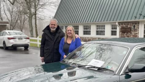 Philanthropist Gene Epstein and Bucks County Opportunity Council CEO Erin Lukoss standing behind green jaguar that Gene Epstein and his wife are donating to a woman through Gene's Wheelz2work program