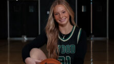 Lauren Greer in Archbishop Wood jersey holding basketball on court in professional photo
