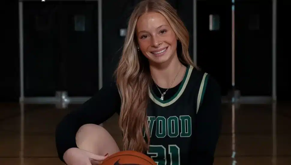 Lauren Greer in Archbishop Wood jersey holding basketball on court in professional photo