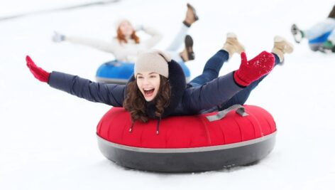 a young woman experiences fun snow-tubing.