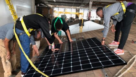 Individuals working on a solar panel