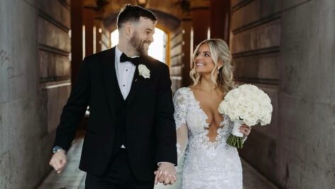 Chas McCormick and Courtney Zadinski hold hands on their wedding day