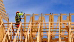 Construction workers working on new home or residential building with wooden beams framed and sky