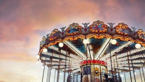 Part of popular vintage, retro carousel (merry-go-round) by the Eiffel Tower in Paris on sky sunset background.