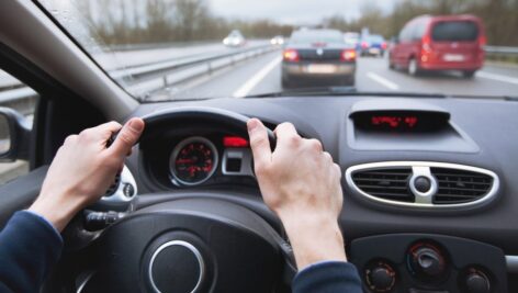driving car on highway, close up of hands on steering wheel