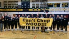 Archbishop Wood girls basketball team on court holding sign that says "can't shop WOOD!!"