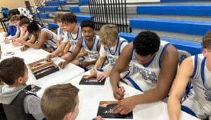 Bensalem boys basketball team autographing for young fans