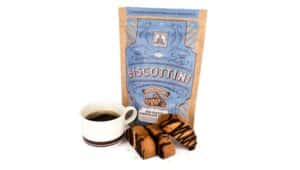 bag of biscottinis with three biscottinis outside of it and a cup of coffee