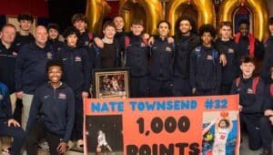 Nate Townsend with team in front of 1,000 points poster.