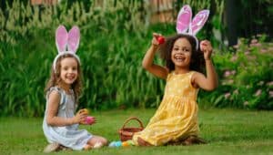 Two girls playing with easter eggs on the lawn