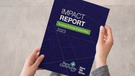 Image of hands holding the 2023 Penn Community Bank Impact Report