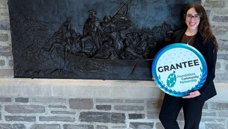 Jennifer Martin, Washington Crossing Historic Park’s Executive Director, posing in front of the artifact that will be used to develop a multi-sensory interpretive experience for blind/visually impaired visitors.