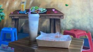 Inside TeaVa Rolls table with spring rolls and Vietnamese coffee in front of mural