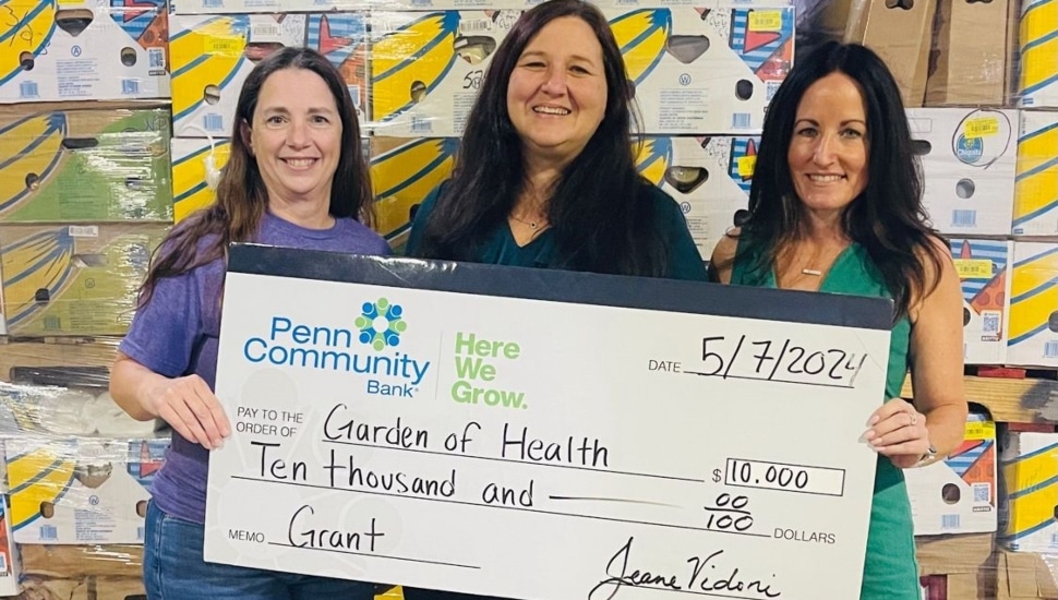 Garden of Health founder Carol Bauer accepts a check from Penn Community Bank Manager of Corporate Social Responsibility & Government Affairs Kelly Boyle and Multi-Site Manager Melanie Scholl.