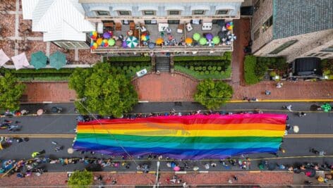 Aerial image of pride parade in new Hope/Lambertville, crowd holding a pride flag