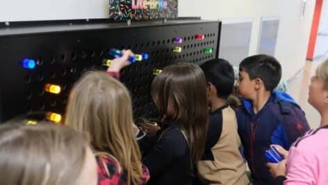 elementary school kids using lite brite wall