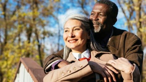 senior couple in love - Elderly married heterosexual and interracial couple embracing outdoors