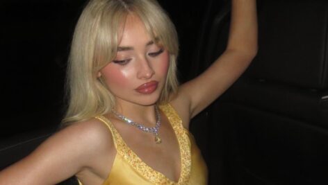 Sabrina Carpenter in a vehicle of sorts wearing yellow dress for birthday