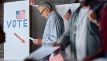 Senior man with a ballot at voting booth during US elections.