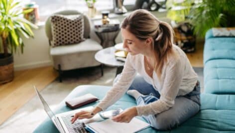 woman sitting on floor of living room on laptop