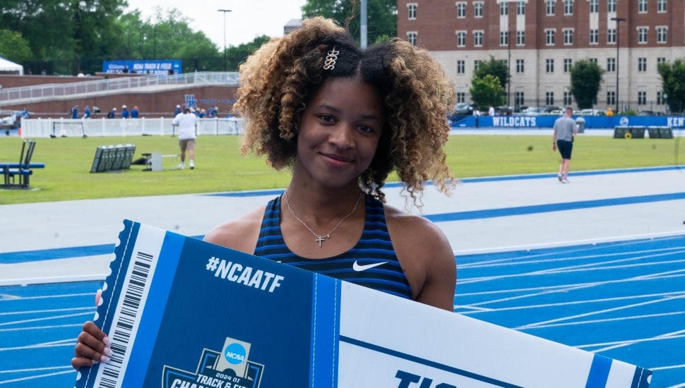 Brianna Smith holding giant punched ticket on track course