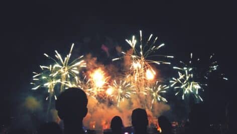 silhouette of people in front of fireworks