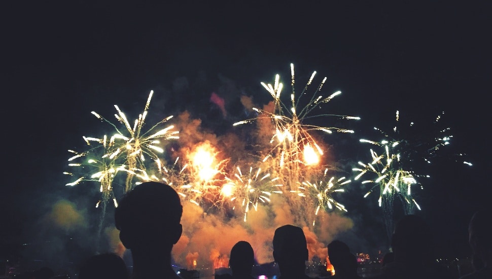 silhouette of people in front of fireworks