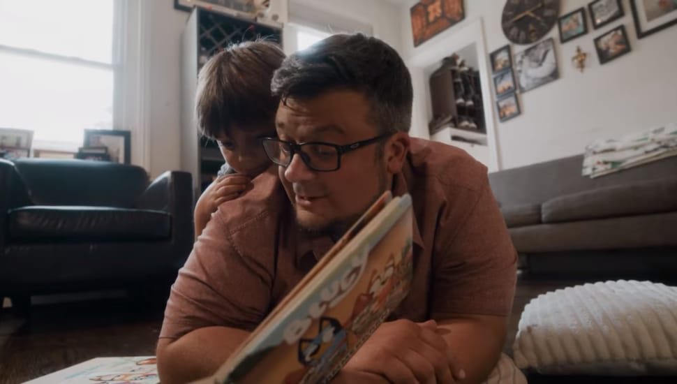 A man reading to his young son.