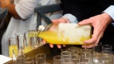 close-up of a waiter serving limoncello in glasses at a part