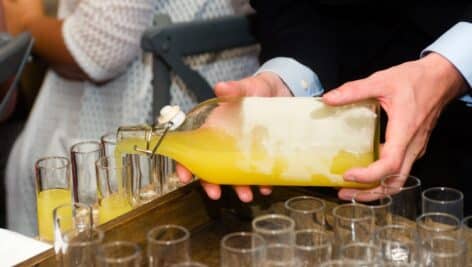 close-up of a waiter serving limoncello in glasses at a part