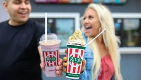 a man holding nerds flavored water ice next to a woman holding soft serve sprinkled with nerds