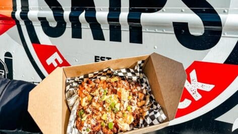 chicken sandwich in cardboard box in front of Skip's food truck