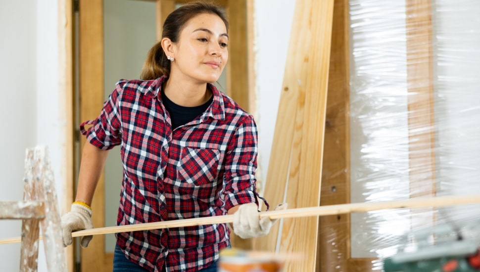 Woman doing home renovation - preparing the door for installation in the doorway