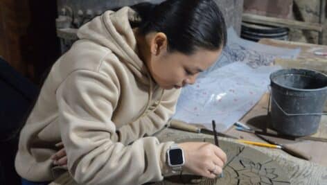 A Penn State Abington student creates a tile as part of a course held each spring at the Moravian Pottery and Tileworks working history museum in Doylestown, Bucks County.