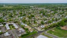 Flight with a drone over a with low houses in small town on a Bensalem