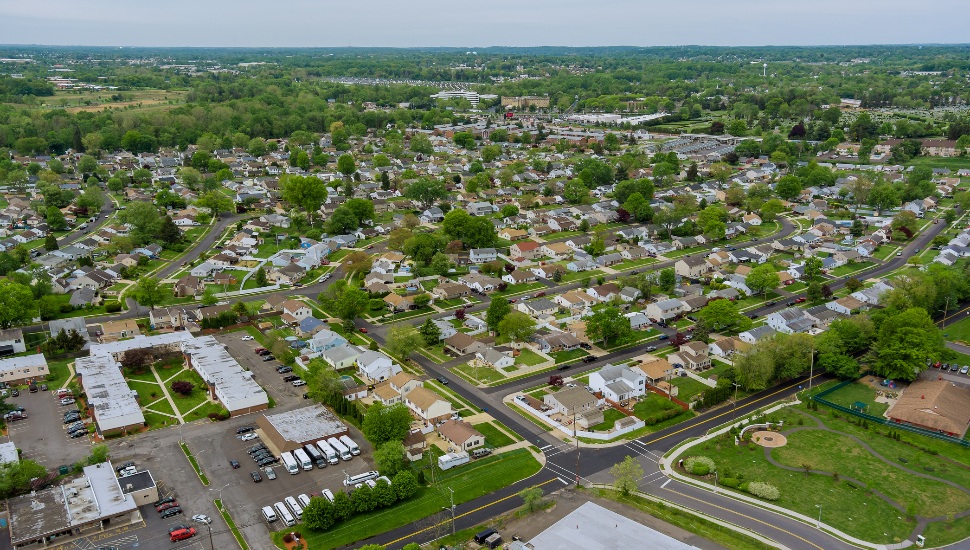 Flight with a drone over a with low houses in small town on a Bensalem