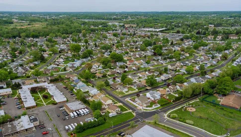 Flight with a drone over a with low houses in small town on a Bensalem
