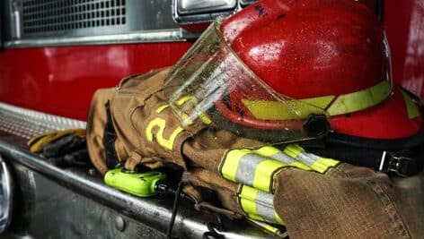 Firefighter protection gear, helmet, gloves on the bumper of the fire truck