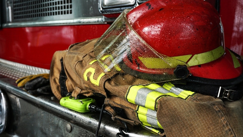 Firefighter protection gear, helmet, gloves on the bumper of the fire truck