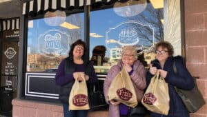 Three women outside Fritz Bakery in Bucks County, holding bags of baked goods.