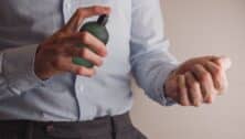 a middle aged man applying cologne