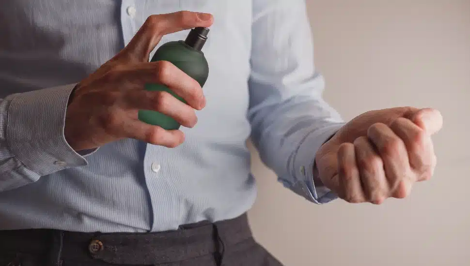 a middle aged man applying cologne