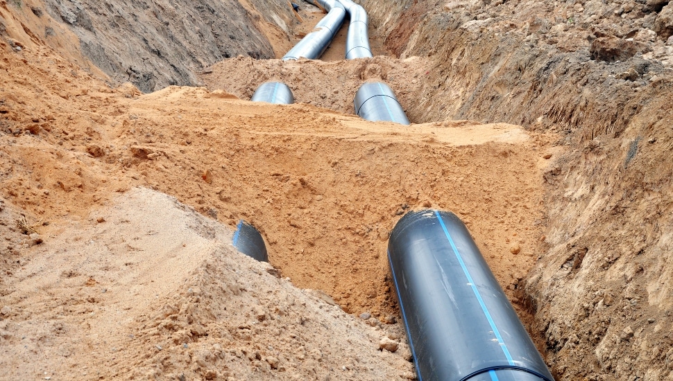 Close up of water pipes being repaired/replaced beneath the dirt.