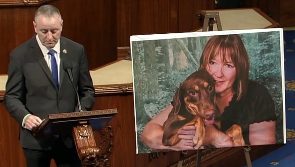 U.S. Rep. Brian Fitzpatrick speaks with photo of the late Susan Barnhart next to him.