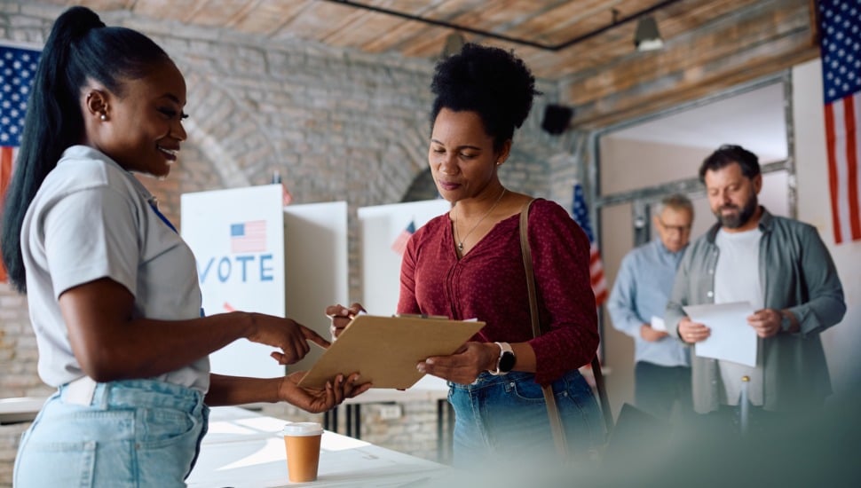 A poll worker helps a voter.