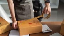 A worker seals a package in preparation for shipping.