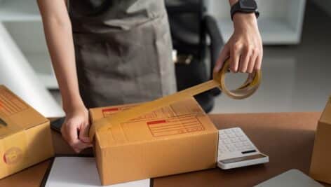 A worker seals a package in preparation for shipping.